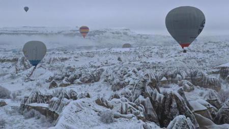 مرة أخرى ..المناطيد الحرارية تحلّق فوق كبادوكيا التركية المتزينة بالثلج
