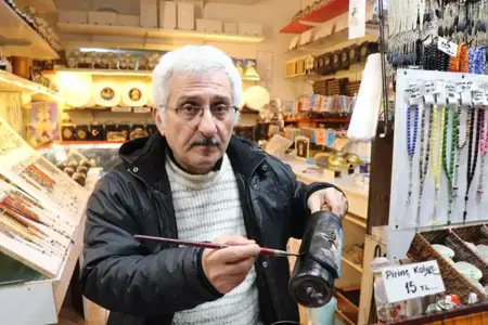 يده تتلف بحرير ..مسن تركي يحقق أرباحاً كبيرة بالرسم على زجاجات الخمور المستعملة