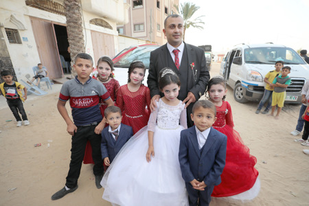 شاب فلسطيني يُزَفُّ إلى زوجته بمشاركة أطفاله السبعة